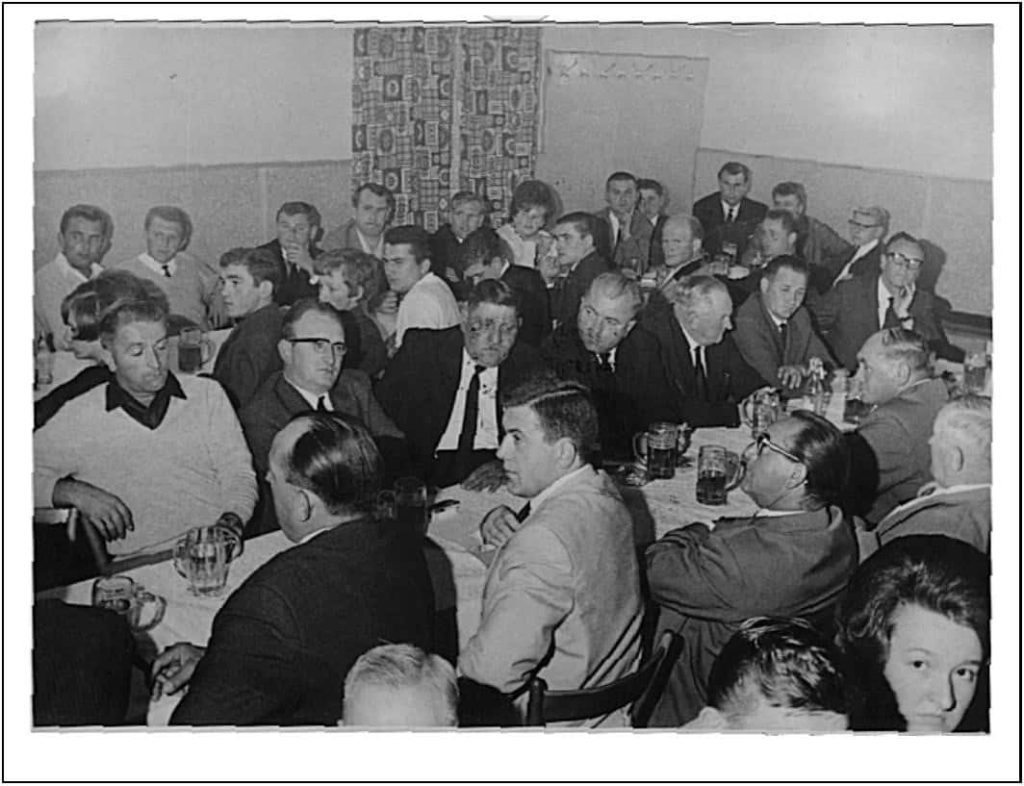 Das Bild zeigt eine Veranstaltung des Vereins im Innenraum. Er ist Prall gefüllt mit Menschen. Es ist ein schwarz-weiß Bild.